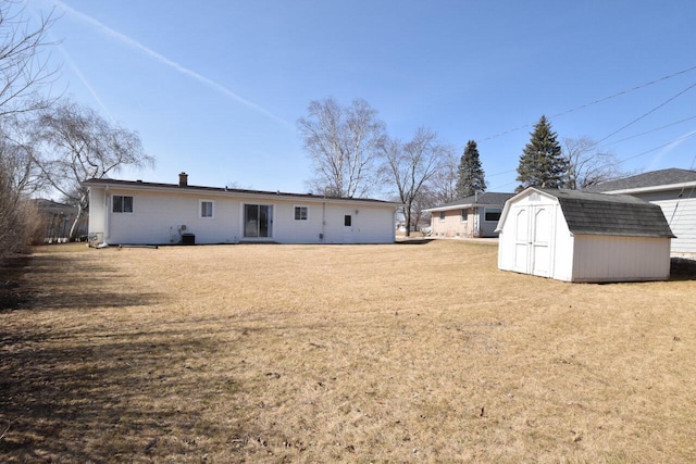 back of property with a lawn, a storage unit, and an outdoor structure