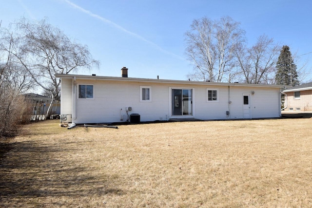 back of house with a lawn and a chimney