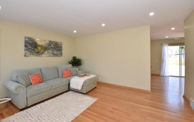 living room with recessed lighting, baseboards, and light wood finished floors