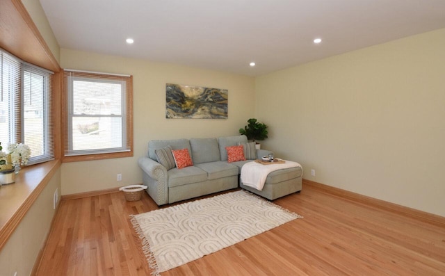 living room with light wood finished floors, recessed lighting, and baseboards