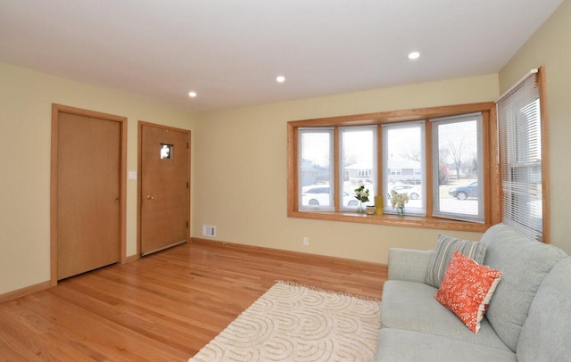 living area with visible vents, recessed lighting, light wood-type flooring, and baseboards