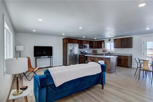 living area with light wood finished floors, recessed lighting, and baseboards