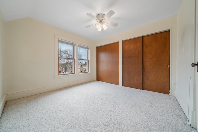 unfurnished bedroom with multiple closets, carpet floors, and ceiling fan