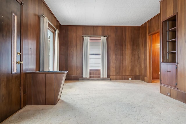 carpeted spare room with wood walls