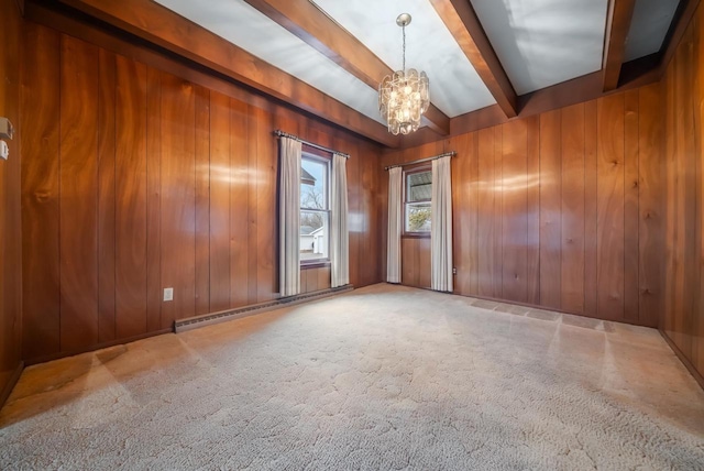 carpeted empty room featuring a notable chandelier, beamed ceiling, wood walls, and a baseboard radiator