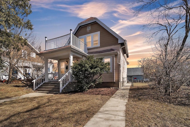 view of front of home featuring a balcony, a gate, and covered porch