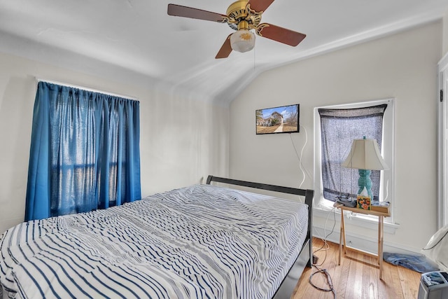 bedroom featuring a ceiling fan, vaulted ceiling, and wood finished floors