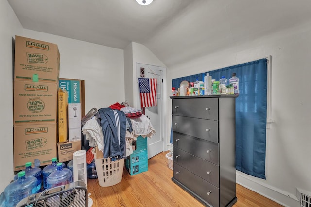 bedroom featuring vaulted ceiling, visible vents, baseboards, and wood finished floors