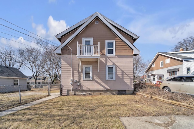 view of front of home with a front yard, fence, a balcony, and a gate