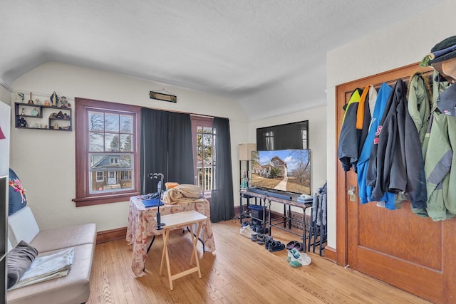 sitting room featuring baseboards, lofted ceiling, a textured ceiling, and hardwood / wood-style floors