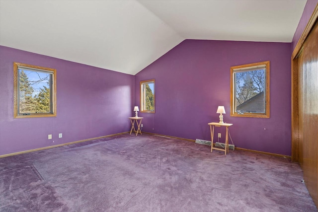 interior space with baseboards, lofted ceiling, and carpet flooring