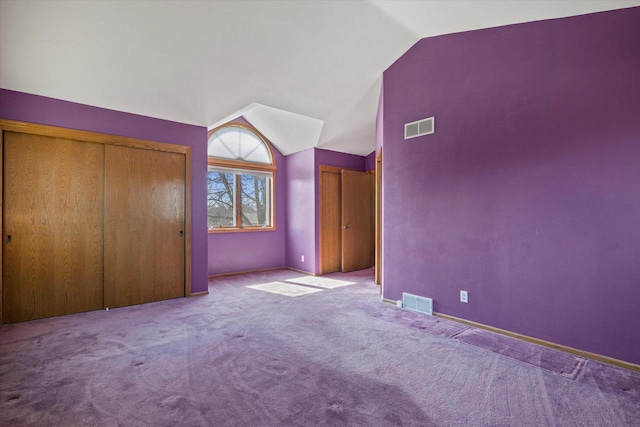 unfurnished bedroom featuring visible vents, baseboards, carpet, and vaulted ceiling