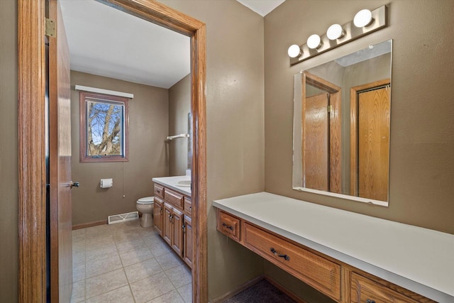 bathroom with vanity, baseboards, visible vents, tile patterned flooring, and toilet