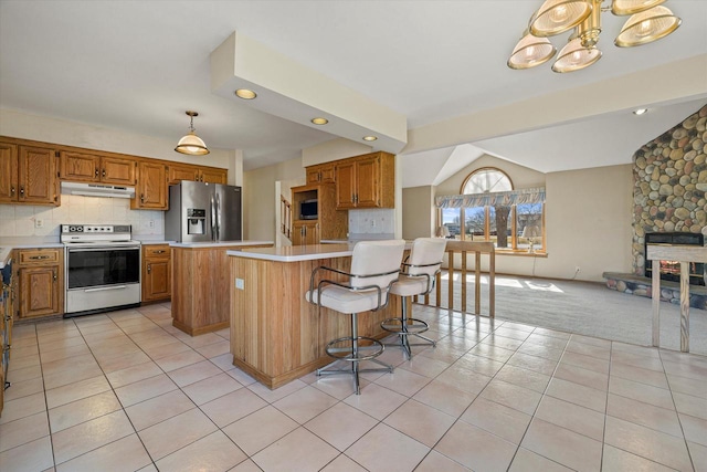 kitchen with white electric range oven, stainless steel fridge with ice dispenser, light countertops, under cabinet range hood, and a center island