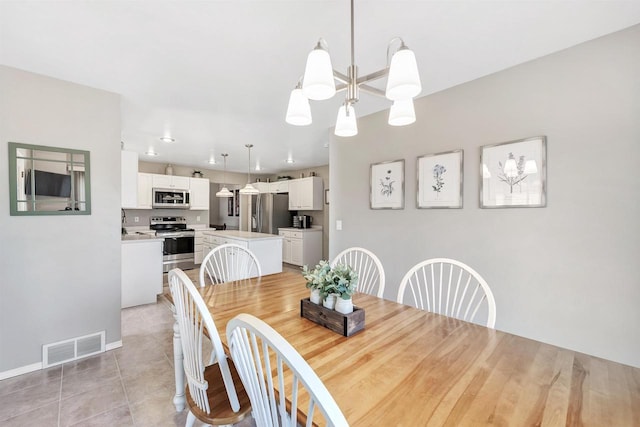 dining area with a notable chandelier, light tile patterned flooring, baseboards, and visible vents