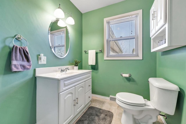 half bathroom with tile patterned floors, toilet, vanity, and baseboards