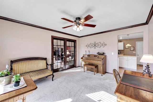 sitting room featuring baseboards, light colored carpet, ornamental molding, and a ceiling fan