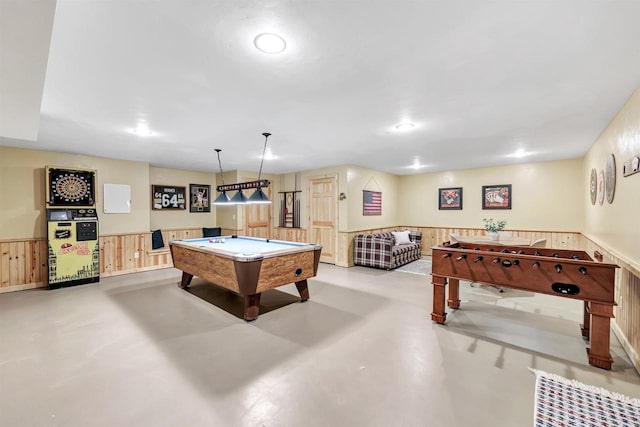 game room featuring a wainscoted wall, pool table, finished concrete flooring, and wooden walls