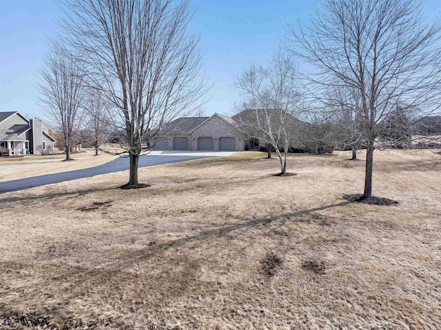 view of yard with driveway and an attached garage