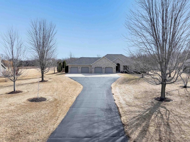 french country inspired facade featuring stone siding, driveway, and a garage