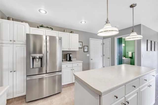 kitchen with a center island, stainless steel fridge with ice dispenser, light countertops, hanging light fixtures, and white cabinetry