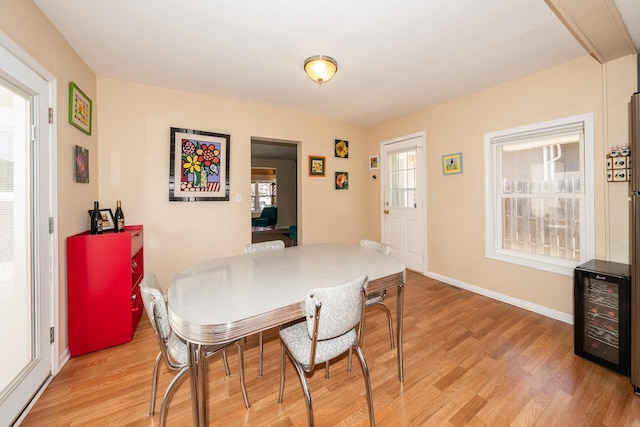 dining area with wine cooler, plenty of natural light, and light wood finished floors