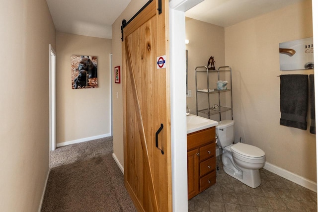 half bathroom featuring vanity, toilet, and baseboards