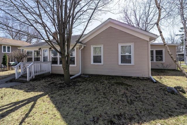 back of house with a lawn and a sunroom