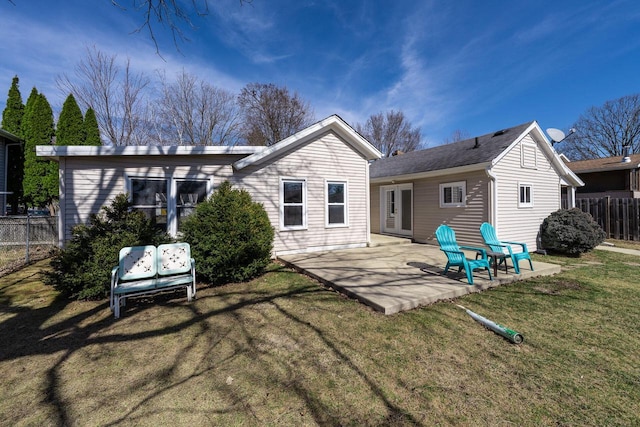 rear view of property featuring a patio area, a lawn, and fence