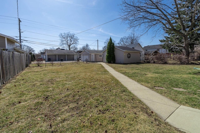 view of yard featuring an outdoor structure and fence