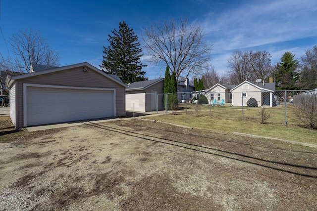 view of front of property with a garage, an outdoor structure, a front lawn, and fence