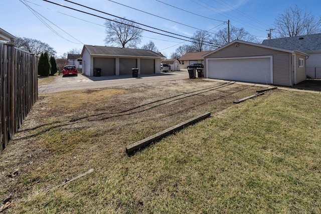 exterior space featuring a garage, an outbuilding, and fence