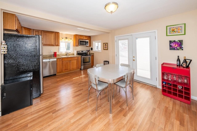 dining space with light wood-type flooring and french doors