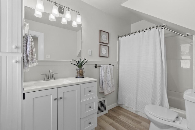 bathroom featuring visible vents, toilet, shower / bath combo, wood finished floors, and vanity