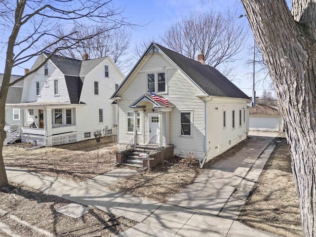 view of front facade with an outbuilding, a chimney, a garage, and roof with shingles