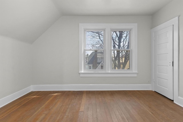 bonus room featuring vaulted ceiling, baseboards, and hardwood / wood-style floors