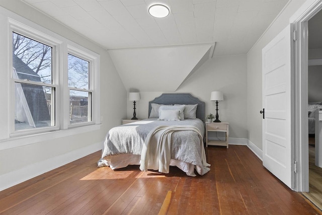 bedroom featuring baseboards, lofted ceiling, and wood-type flooring