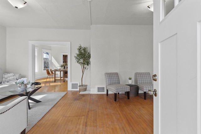 sitting room featuring visible vents, baseboards, and hardwood / wood-style floors