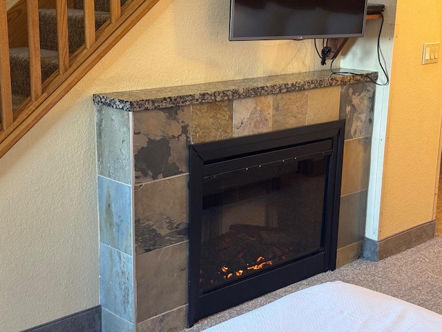 details with a glass covered fireplace and a textured wall