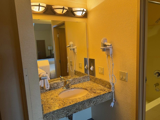 bathroom with a textured wall and a sink