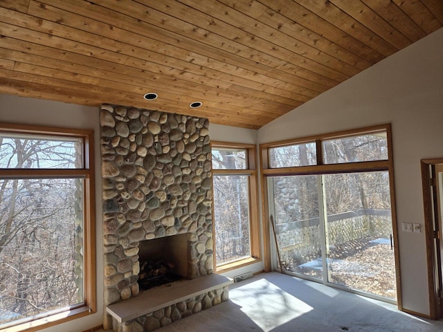 unfurnished living room with lofted ceiling, wood ceiling, a fireplace, and carpet floors