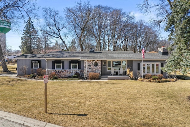 ranch-style house featuring stone siding, covered porch, a chimney, and a front yard