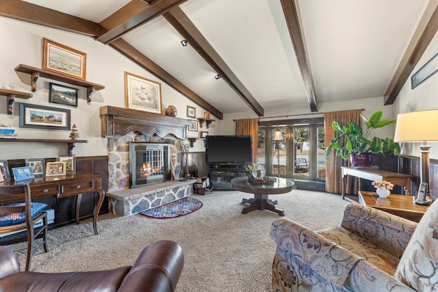 living area with a stone fireplace, lofted ceiling with beams, and carpet