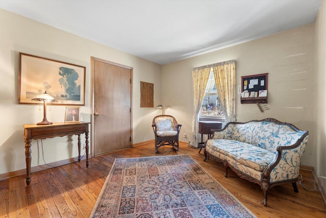 living area featuring hardwood / wood-style flooring and baseboards