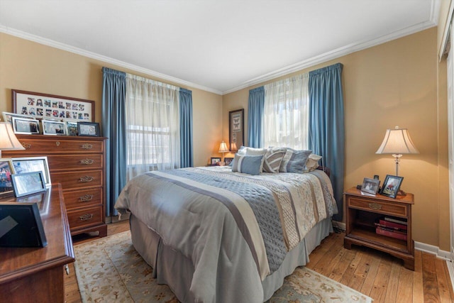 bedroom featuring light wood-style floors, baseboards, and ornamental molding