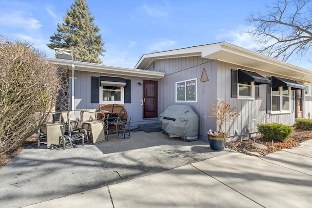 rear view of property featuring a chimney and a patio area