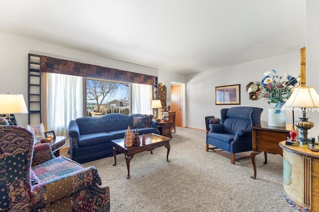 carpeted living area with baseboards