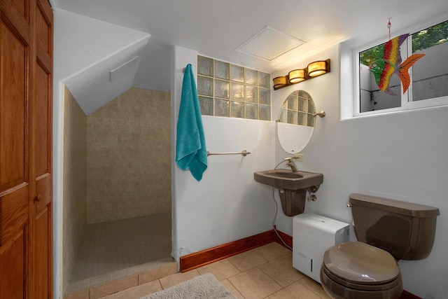 full bathroom featuring baseboards, a sink, a walk in shower, tile patterned floors, and toilet