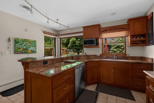 kitchen with a peninsula, stainless steel appliances, a sink, a baseboard heating unit, and brown cabinets