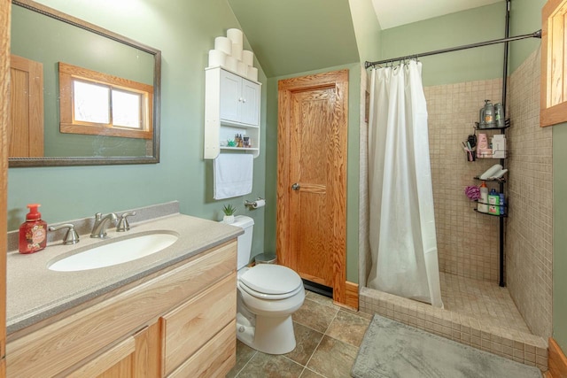 bathroom featuring vanity, toilet, and a tile shower